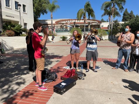 Students play trombones in an attempt to drown out the words of man spewing hate speech.