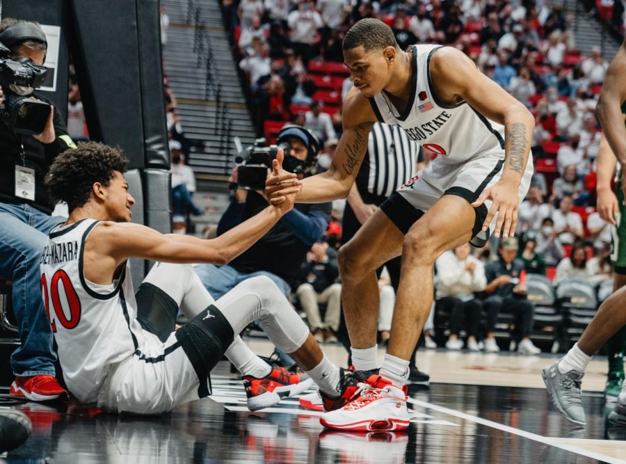 Chad Baker-Mazara (left) gets helped up to his feet by Keshad Johnson (right) during SDSUs Jan. 8 match against Colorado State. The team will now be on a temporary pause due to COVID-19 quarantine protocols.