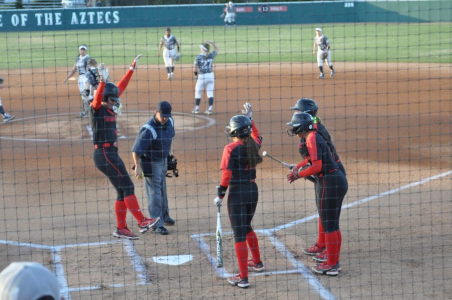 Jessica+Cordola+gets+greeted+by+three+of+her+teammates+at+home+plate+after+hitting+a+three-run+homerun+against+Army.+