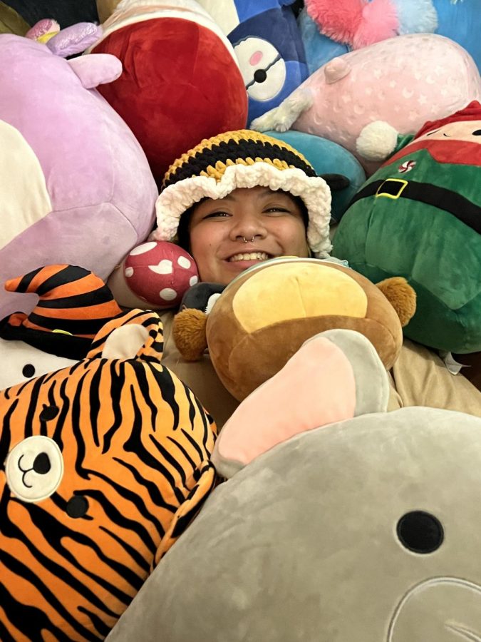 Fifth year applied mathematics major Kaylani Cayabyab gleefully laying on top of her Squishmallows.