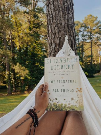 Alexander pictured in a hammock while taking photo of her current read. 