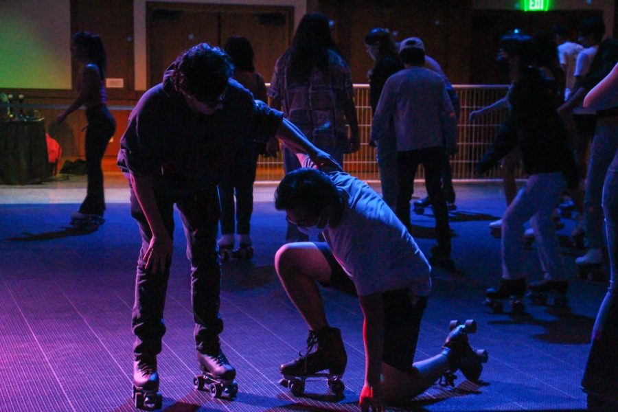 Students helping each other get up while skating. 