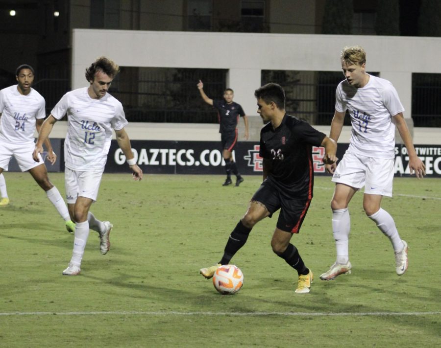 Senior midfielder Blake Bowen protects the ball from a pair of UCLA defenders on Nov. 11. 