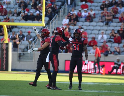 From left to right, senior linebacker Michael Shawcroft, sophomore cornerback Noah Avinger and junior safety Davaughn Celestine celebrate a stop during a game against UNLV on Nov. 5. 