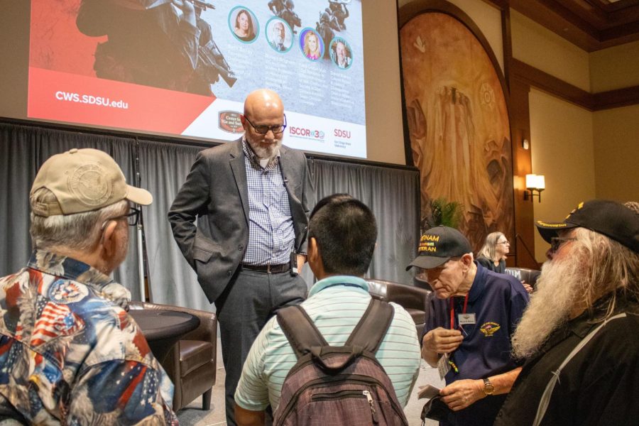 Robert Brigham, professor of History and International Relations at Vassar College, talks with Vietnam veterans and a student after the panel in Montezuma Hall on Nov. 10.