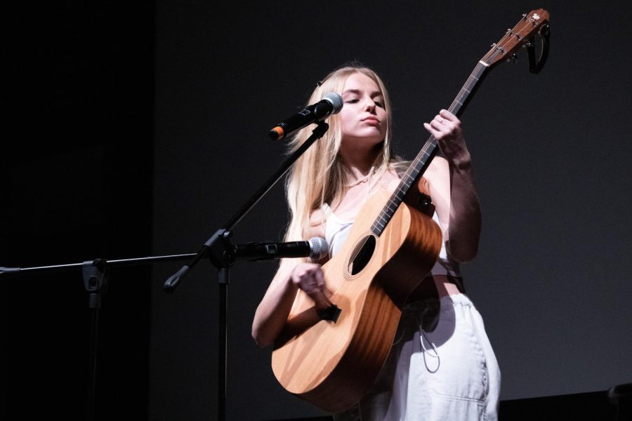 Hannah Geller swings her guitar to the beat as she performs her original song Song for No One in the Montezuma Hall Theater on Dec. 6.