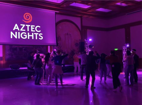 Students dance in front of the DJ booth.