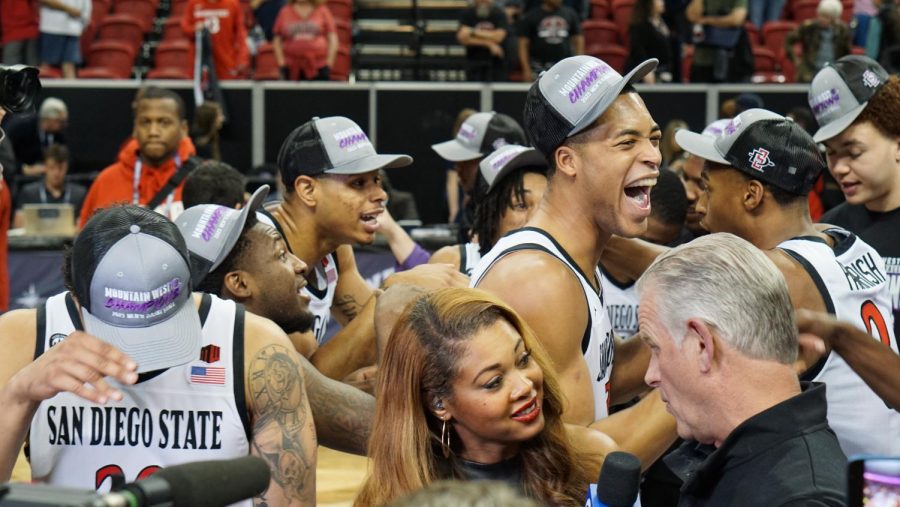 The Aztecs celebrate their Mountain West Title while Brian Dutcher is interviewed on Saturday, March 11.