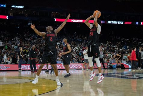 Senior Tyler Broughton shoots over the arm of senior Adam Seiko during SDSU's first open practice on Friday, March. 31 at the NRG Center.