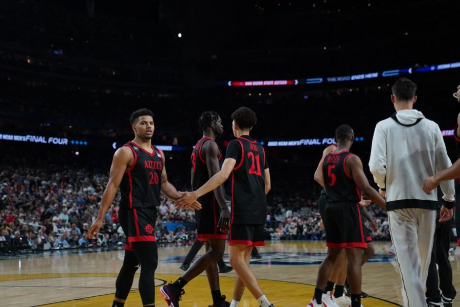 SDSU senior Matt Bradley walks towards the Aztec bench while high-fiving freshman Miles Byrd during SDSUs 76-59 loss to UConn in the National Championship on Monday, April 4.
