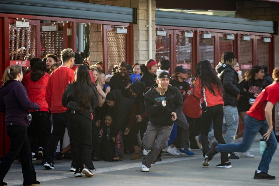 SDSU students storm through the gates at the Viejas Arena on Monday, April 3 in San Diego, CA. Students were seen jumping the gates and opening the doors, letting hundreds of students flood the entrance despite warnings that the stadium was at max capacity.