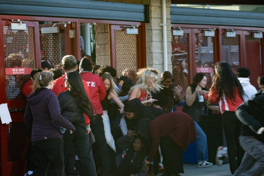 Students help a girl who fell in front of students stampeding the entrance of Viejas Arena on Monday, April 3 in San Diego, CA. Students were seen jumping the gates and opening the doors, letting hundreds of students flood the entrance despite warnings that the stadium was at max capacity.