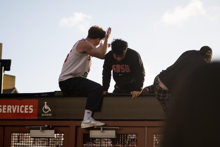 Students jump the gate at the Viejas Arena on Monday, April 3 in San Diego, CA. Students were seen jumping the gates and opening the doors, letting hundreds of students flood the entrance despite warnings that the stadium was at max capacity.