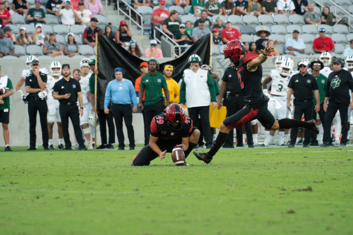 San Diego State kicker Jack Browning (13) kicks out of the hold of Zechariah Ramierez (49) on Saturday, Aug. 26 at Snapdragon Stadium. Both Browning and linebacker Cody Moon earned Mountain West Player of the Week honors after the Aztecs beat Ohio 20-13 in week zero.