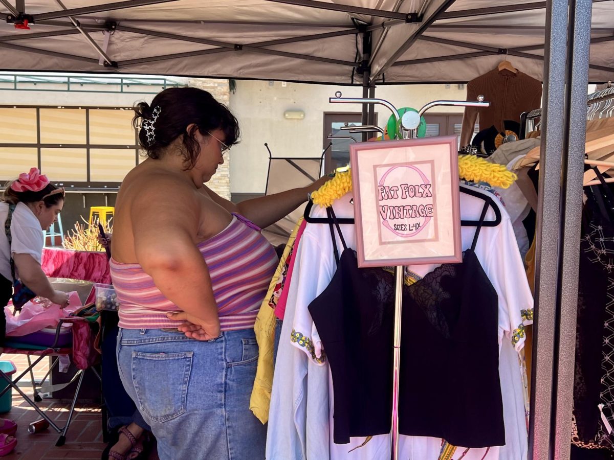 A customer looks through the clothing racks at Fat Folx Vintage, a plus-sized vintage fashion shop owned by Eirene Rocha. Rocha works alongside Bianca Bruno, owner of Staten Island Mermaid, to bring clothes and hardware curated from local estate sales and thrift stores in San Diego.