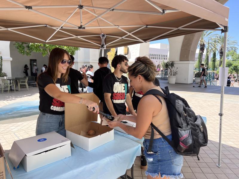 One SDSU leadership passes out conchas at their Kickoff Event. The event also featured information and resources connecting with the theme Know Yourself, Connect with Others, Embrace Diversity.