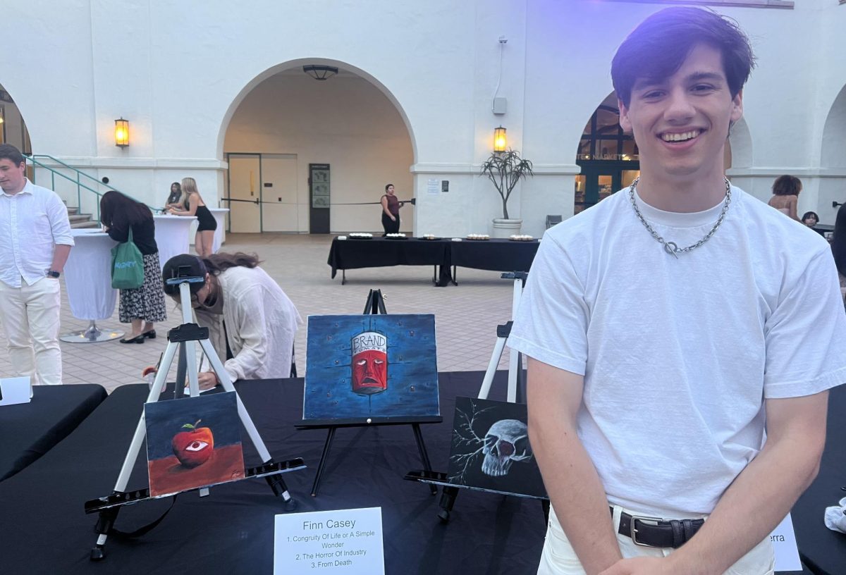 Student+artist+Finn+Casey+poses+with+his+displayed+work+at+the+Golden+Galleria.