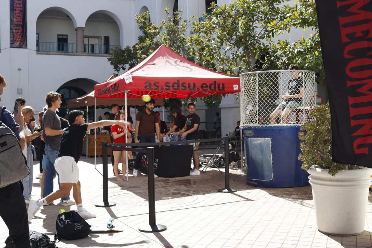 Students participate in a dunk tank to benefit Aztecs Rock Hunger at the Homecoming Kickoff event.