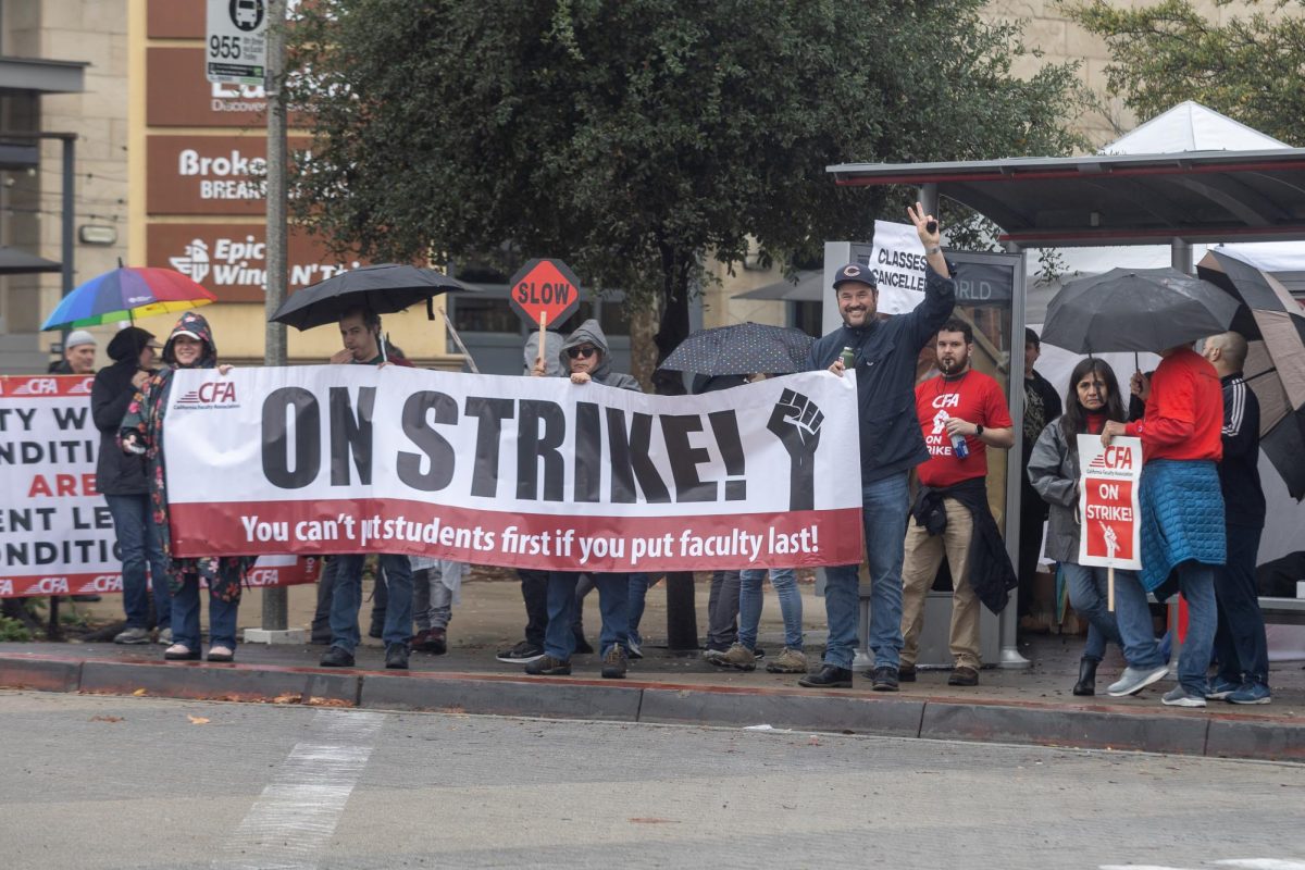 Members of the California Faculty Association (CFA) gathered at a bus stop on the San Diego State University campus, holding signs in support of a CFA strike advocating for improved paid and working conditions on Jan.  22, 2024