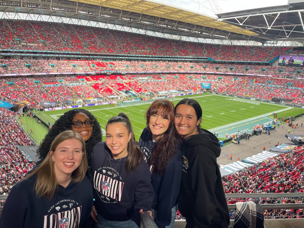 LaChica Sports Global Sport Business Immersion program students (from left to right: Jenna Fassio, Trinity Woodson, Brooklyn Moors, Ciara Dalton, and Emma Lian) enjoying the combination of sports industry insights and fan excitement at the Jacksonville Jaguars vs. Atlanta Falcons game at Wembley Stadium on Oct.1, 2023. (Image courtesy of LaChica Sports)
