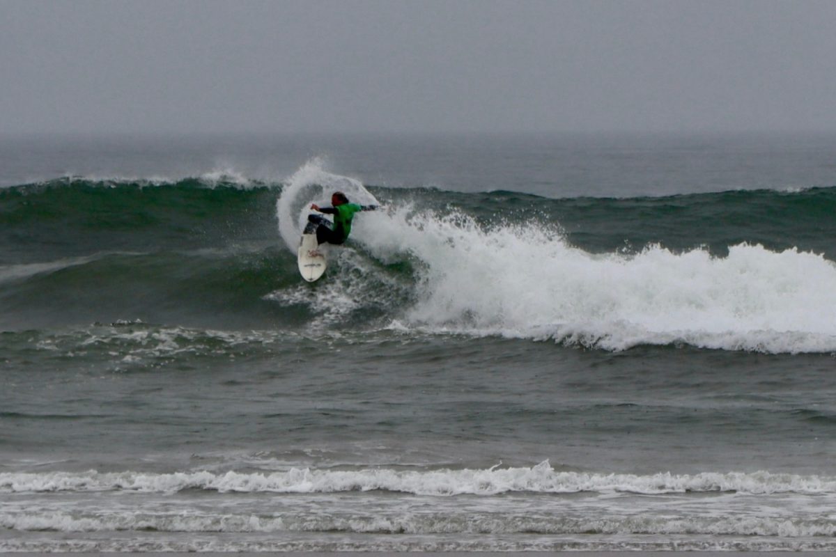 San Diego State surfer Jake Dowling carves a wave in a green jersey during his performance in heat 6 of round 2 on Jan. 20. 
