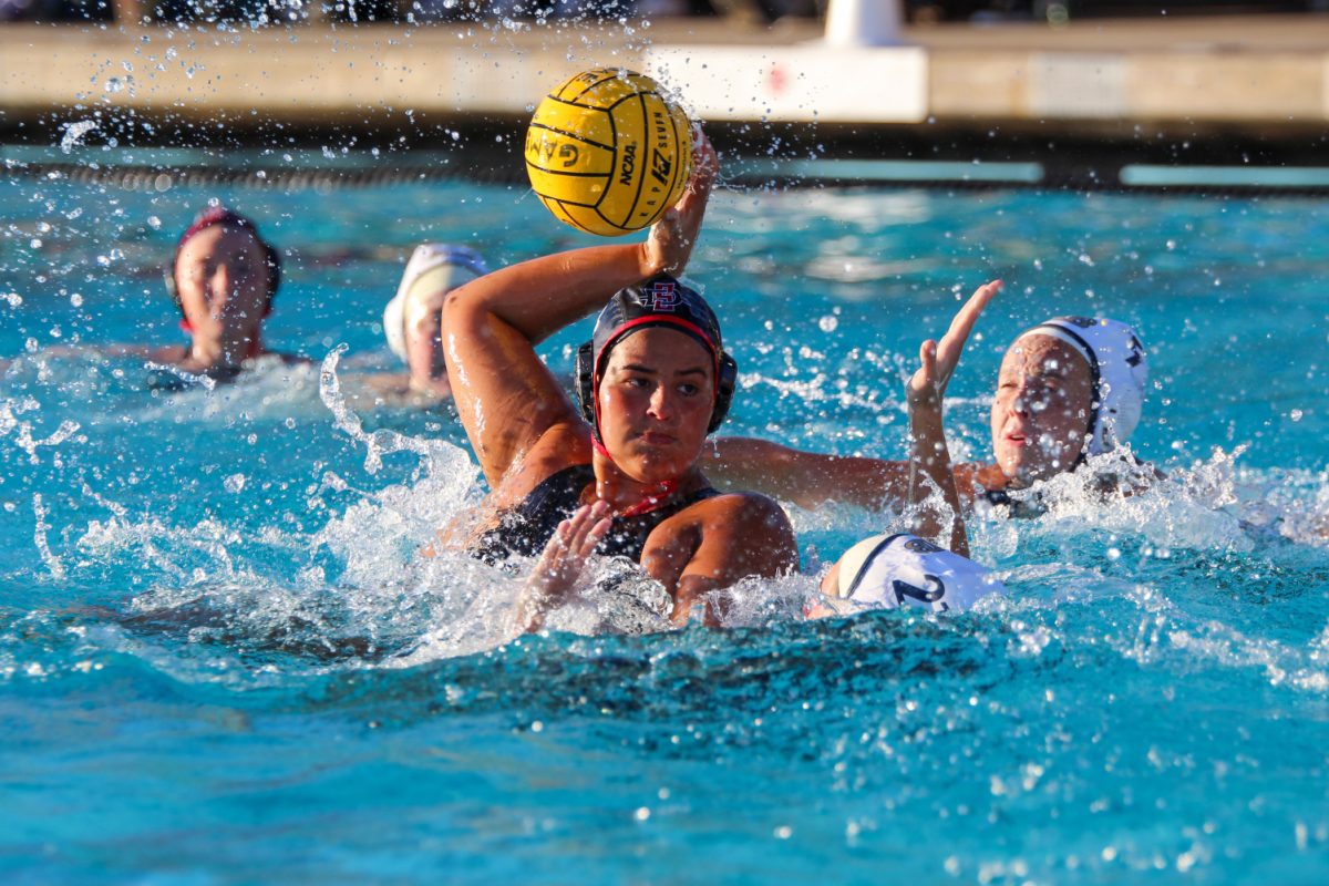 Aiming for the net, utility player Makena Macedo (#14) scores a goal during a water polo match versus Cal State Monterey Bay on Feb. 10. The SDSU Aztecs won 18-3 against the Otters during their home opener this past Saturday.