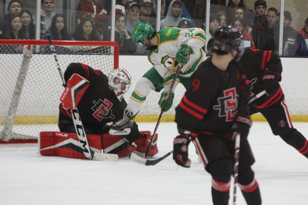 San Diego State goalie Garrett Fuller makes a save through traffic with an attempted deflection by Oregon forward Nick Slayton on Saturday, Feb. 10 at Kroc Center Ice. Fuller made 40 saves to earn his second-straight shutout in the Aztecs 3-0 win over the Ducks.