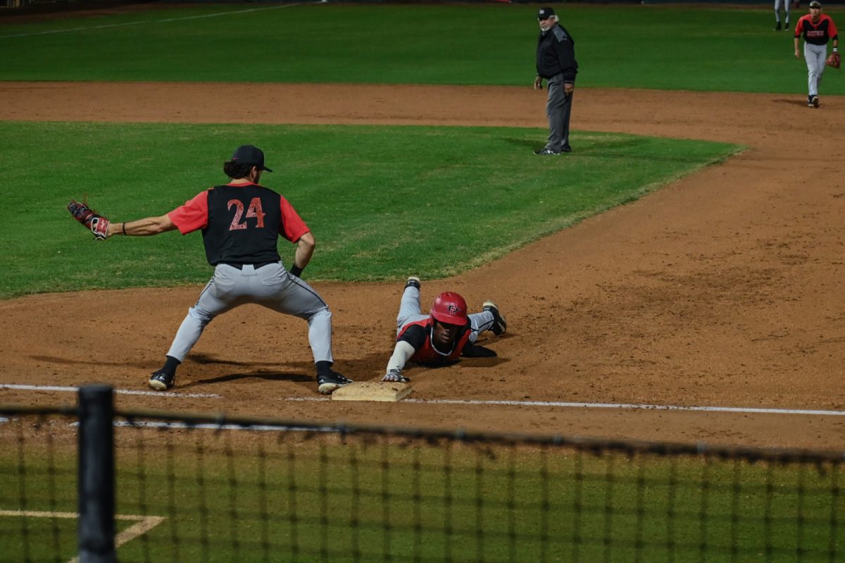 Junior outfielder Irvin Weems dives back to first base as redshirt junior first baseman Brady Lavoie covers during the Red-Black exhibition game during fall 2023 at Tony Gwynn Stadium.