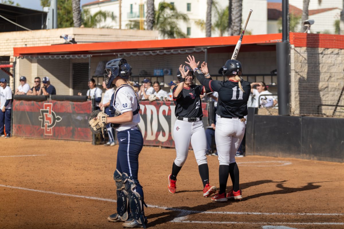 San Diego State right fielder Angie Yellen (24) high fives catcher Cali Decker (11) during the Aztecs 14-0 run-rule win over Utah State on Saturday, March 16 at the SDSU Softball Stadium.