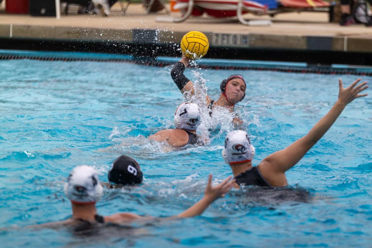 San Diego State utility Makena Macedo with the ball in play guarded by a pair of University of Pacific defenders at the Aztec Aquaplex. The Aztecs lost to the Tigers 8-5 on March 23.