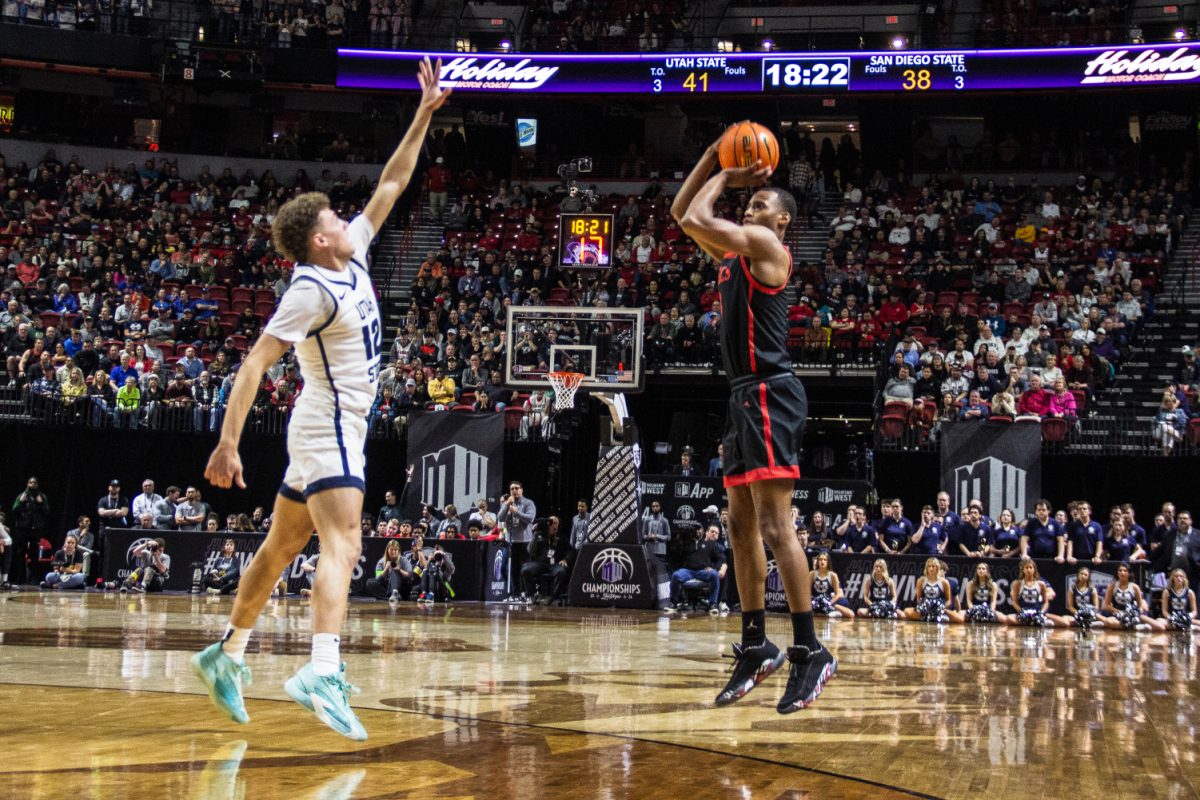 San Diego State guard/forward Micah Parrish lines up a shot over Utah State guard Mason Falslev in the first semifinal of the 2024 Mountain West Mens Championship at the Thomas & Mack Center in Las Vegas. Parrish scored 15 points in the Aztecs 86-70 win over the outright regular season champion Aggies.