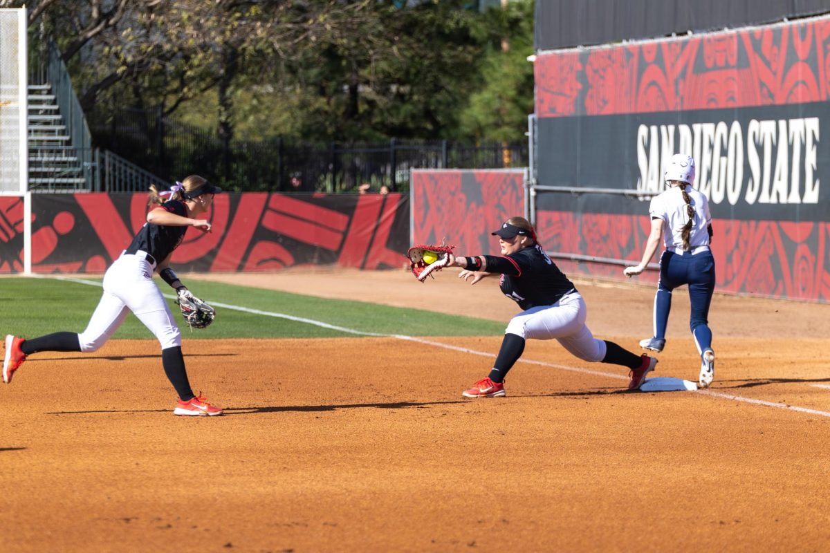 Utility Mac Barbara catches a ball at plate as a hitter runs towards the base earlier this season at SDSU Softball Stadium. The Aztecs defeated San Jose State in a 2-1 victory. 