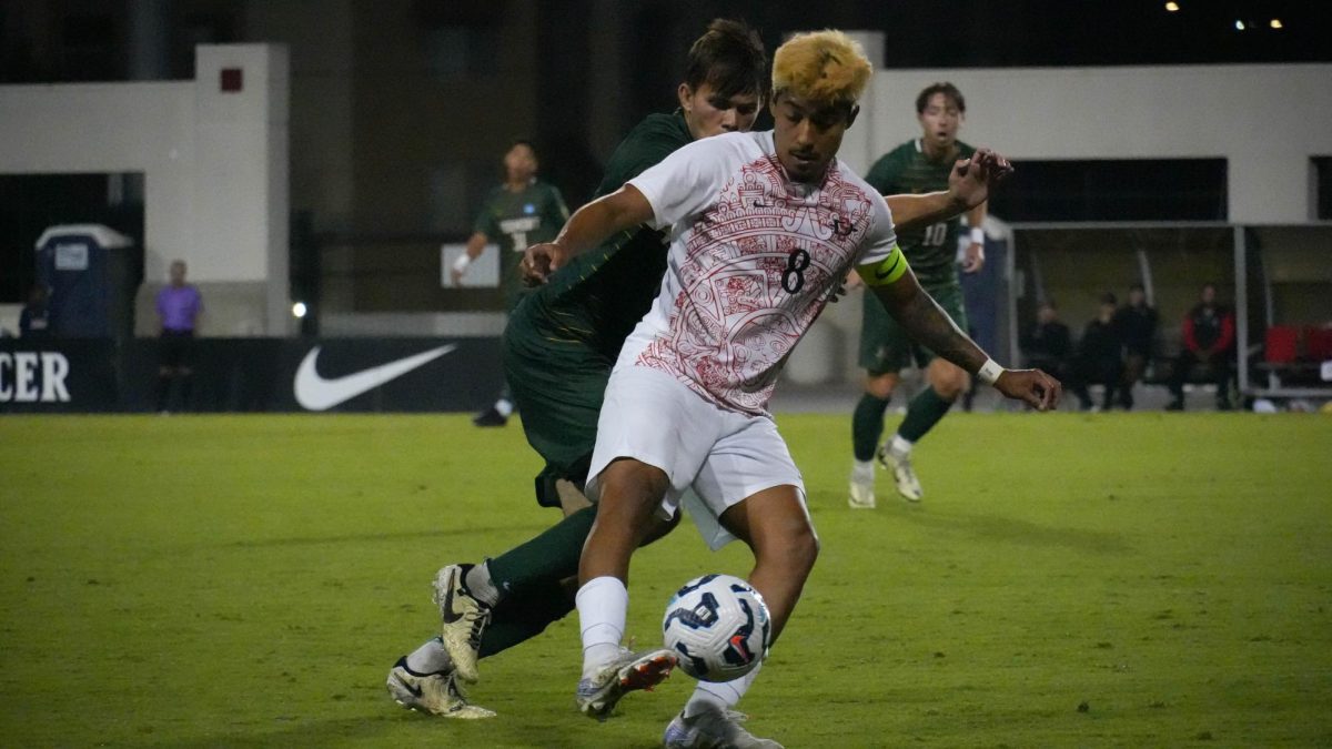 San Diego State midfielder Beto Apolinar looks to keep possession of the ball away from a Vermont defender at SDSU Sports Deck on Monday, Sept 2. The Aztecs lost to the Catamounts 0-1 in their first non-conference home matchup loss in over two years. 