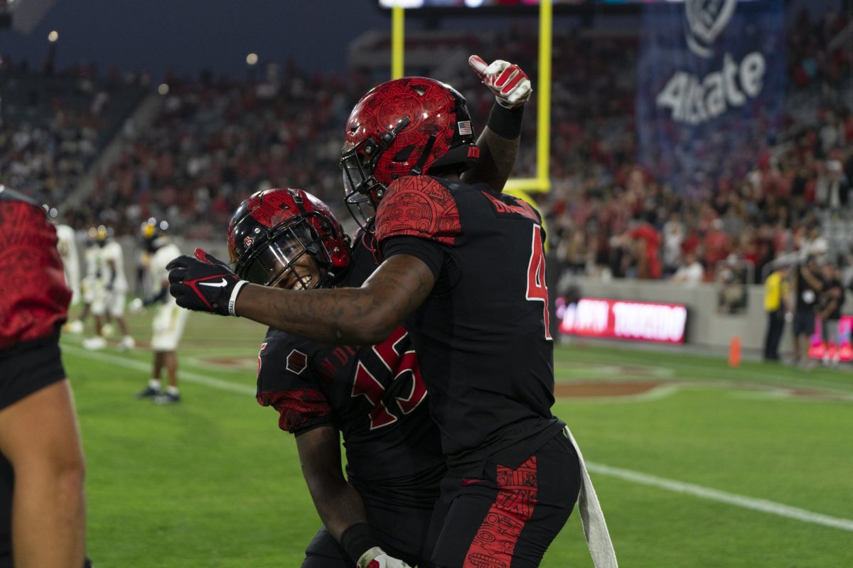 Marquez Cooper and Louis Brown IV celebrate a late game score against the Texas A&M Commerce Lions at Snapdragon stadium Aug. 31, 2024