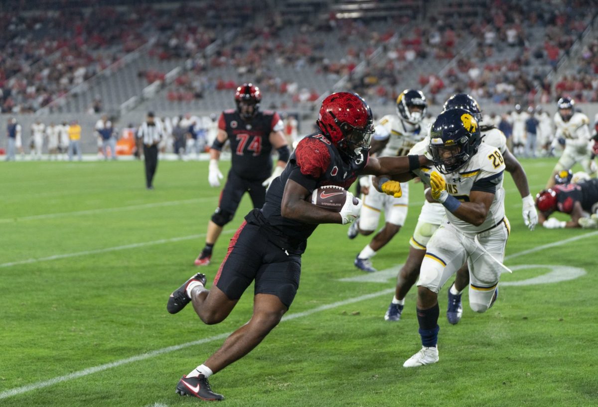 Jordan Napier holds off the Texas A&M - Commerce defender at Snapdragon Stadium on Aug. 31, 2024