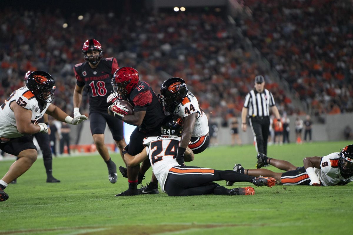 Running back Marquez Cooper protects the ball at Snapdragon Stadium on Sept. 7, 2024