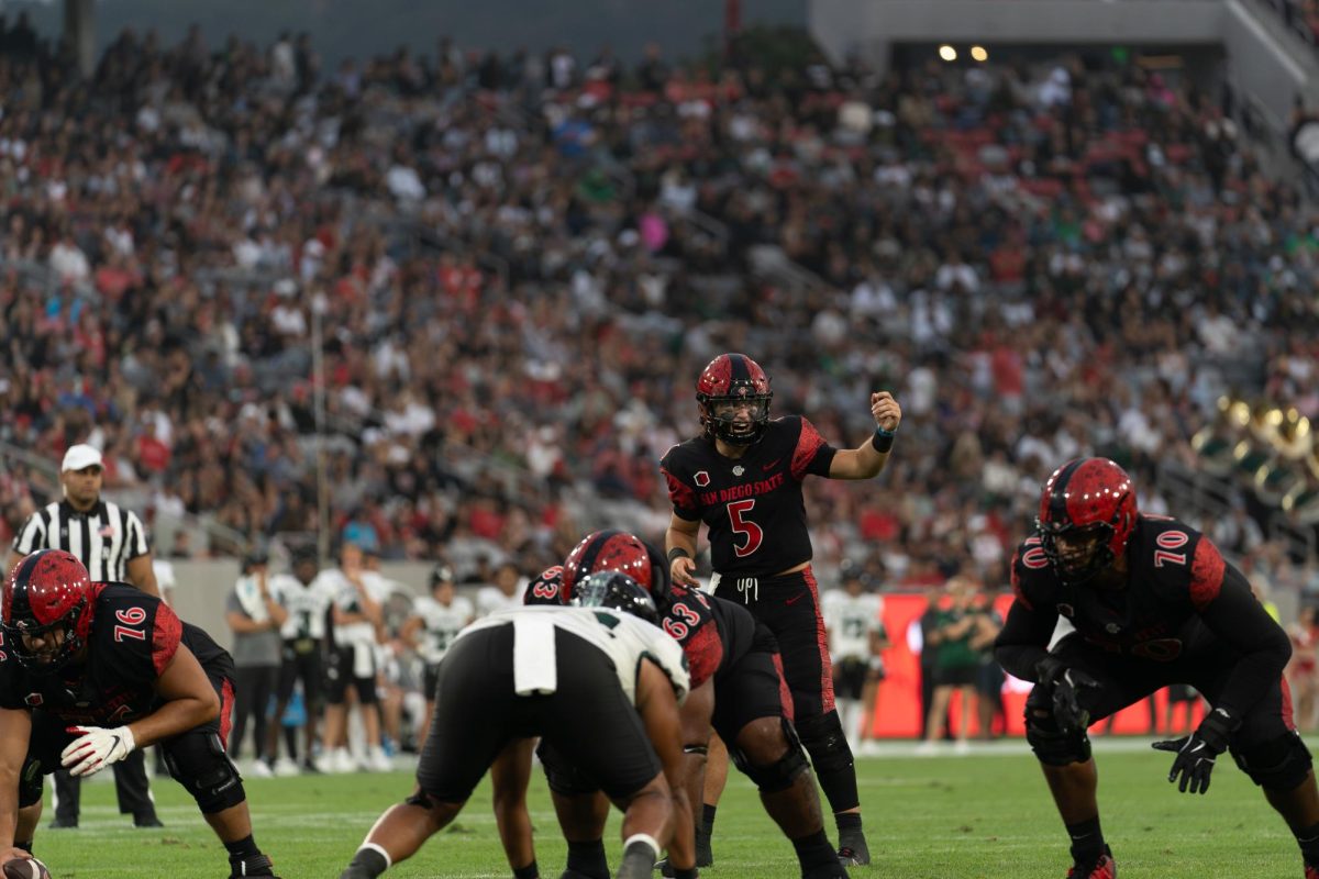 Freshmen Quarterback Danny O'Neil motions senior running back Marquez Cooper against the Hawaii Rainbow Warriors at Snapdragon Stadium on Saturday October 5, 2024. 