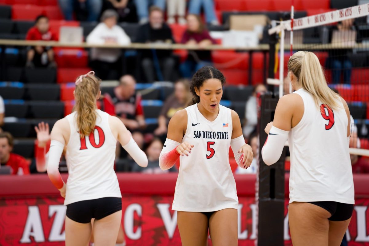 Teammates Talea Mitchell, Taylor Underwood, and Shea Rubright stay in high spirits after another aztec point against Colorado State University at Aztec Court in Peterson Gym on October 17, 2024.
