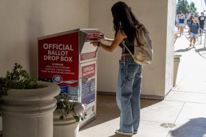 A student dropping off their mail-in ballot at the SDSU ballot drop box on Tuesday, Nov. 5.