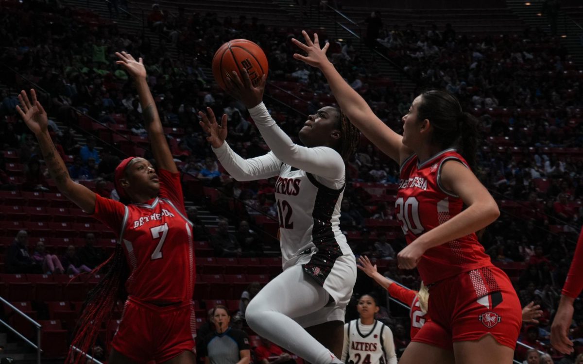 San Diego State freshman guard Kaelyn Hamilton goes for a layup contested by Bethesda guard Makaia Smith (left) and center/forward Selene Romero (right) in a 107-36 win on Friday, Dec. 6 at Viejas Arena.