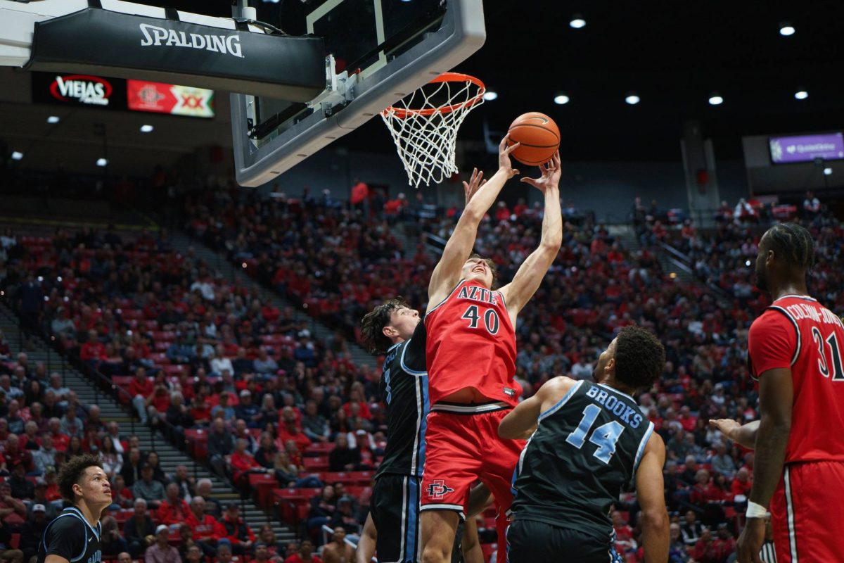 San Diego State forward Miles Heide beats the USD player to the rebound at Viejas Arena on Dec. 7, 2024. 