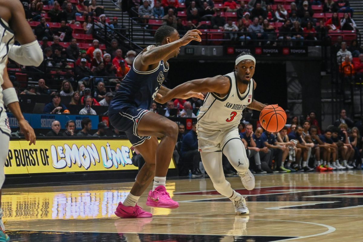 San Diego State senior guard Wayne McKinney III blocks his opponent as he runs down the court in the game against California Baptist University on December 12, 2024.