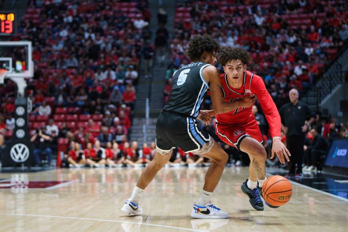 San Diego State guard Miles Byrd drives down the court, breaking free of a USD player's defense at Viejas Arena on Dec. 7, 2024