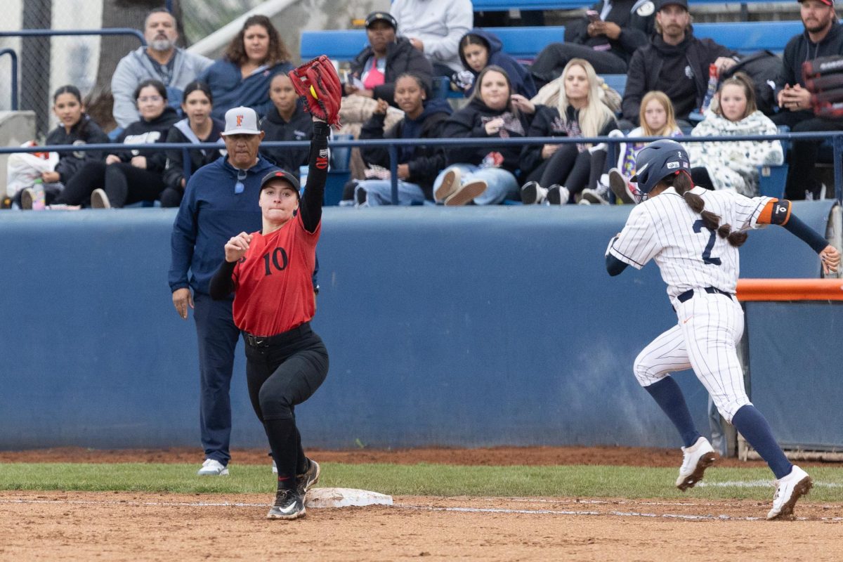  San Diego State first baseman Kate Farren catches a throw at first base to force out Cal State Fullerton shortstop Sarah Perez on Friday, Feb. 7, 2025, at Fullerton, Calif.