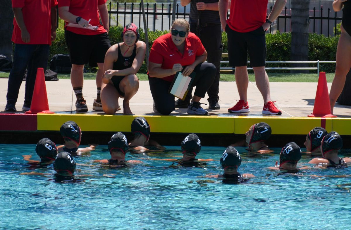 Head coach Dana Ochsner speaks with the team during a timeout last season at the Aztec Aquaplex.