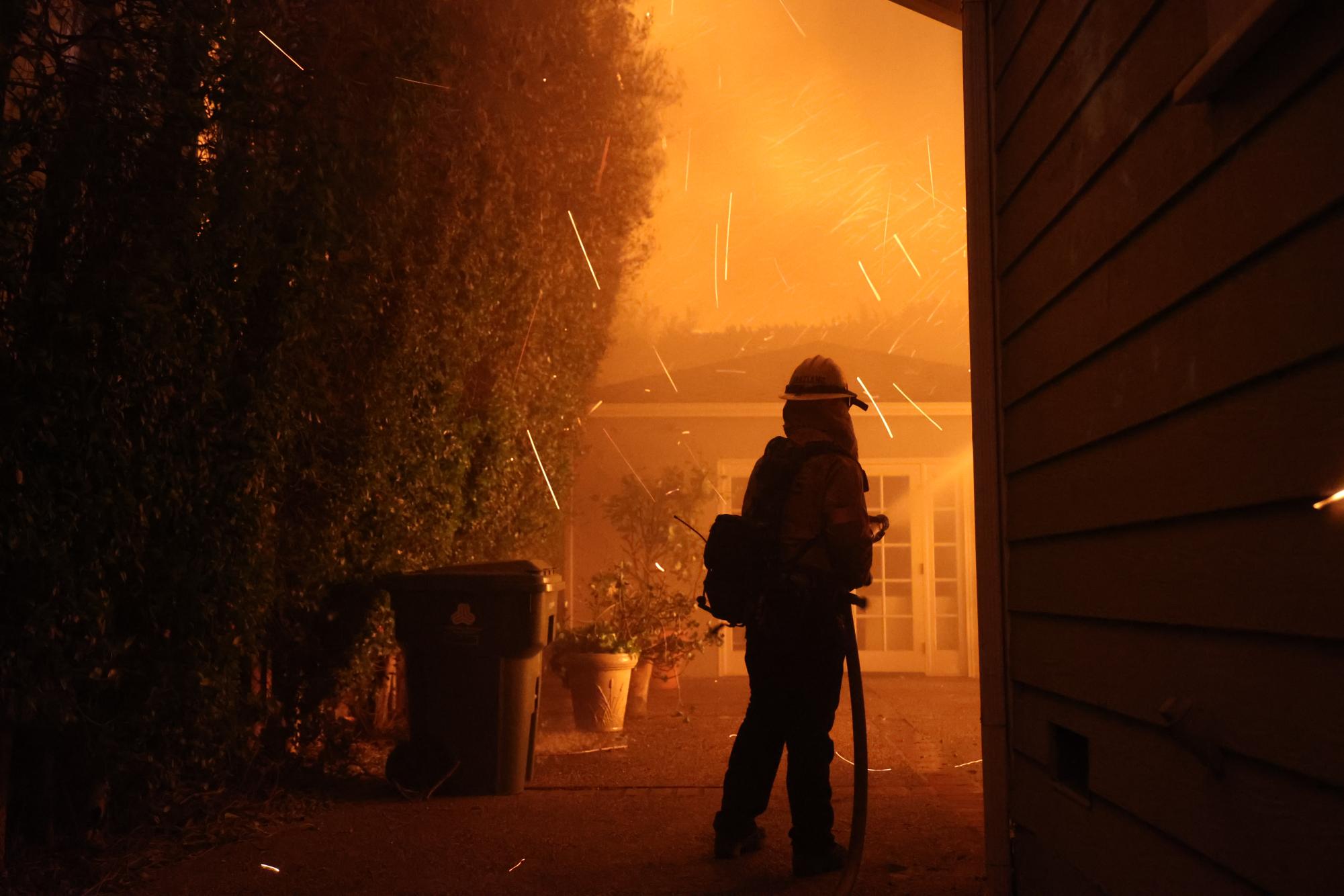 A firefighter works to fight a portion of the Palisades Fire near a home in Los Angeles, Calif. on Wednesday, Jan. 8 2025. (CAL FIRE)