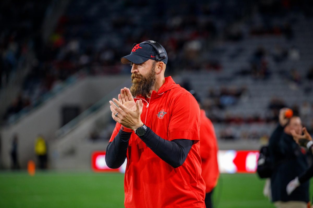 San Diego State football head coach Sean Lewis claps the team as he looks onto the field last season at SnapDragon Stadium on Nov. 30, 2024. 