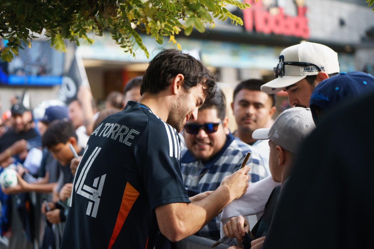 Luca de la Torre signs a fan's sleeve at the San Diego FC kickoff party at Snapdragon Stadium on Feb. 16. 