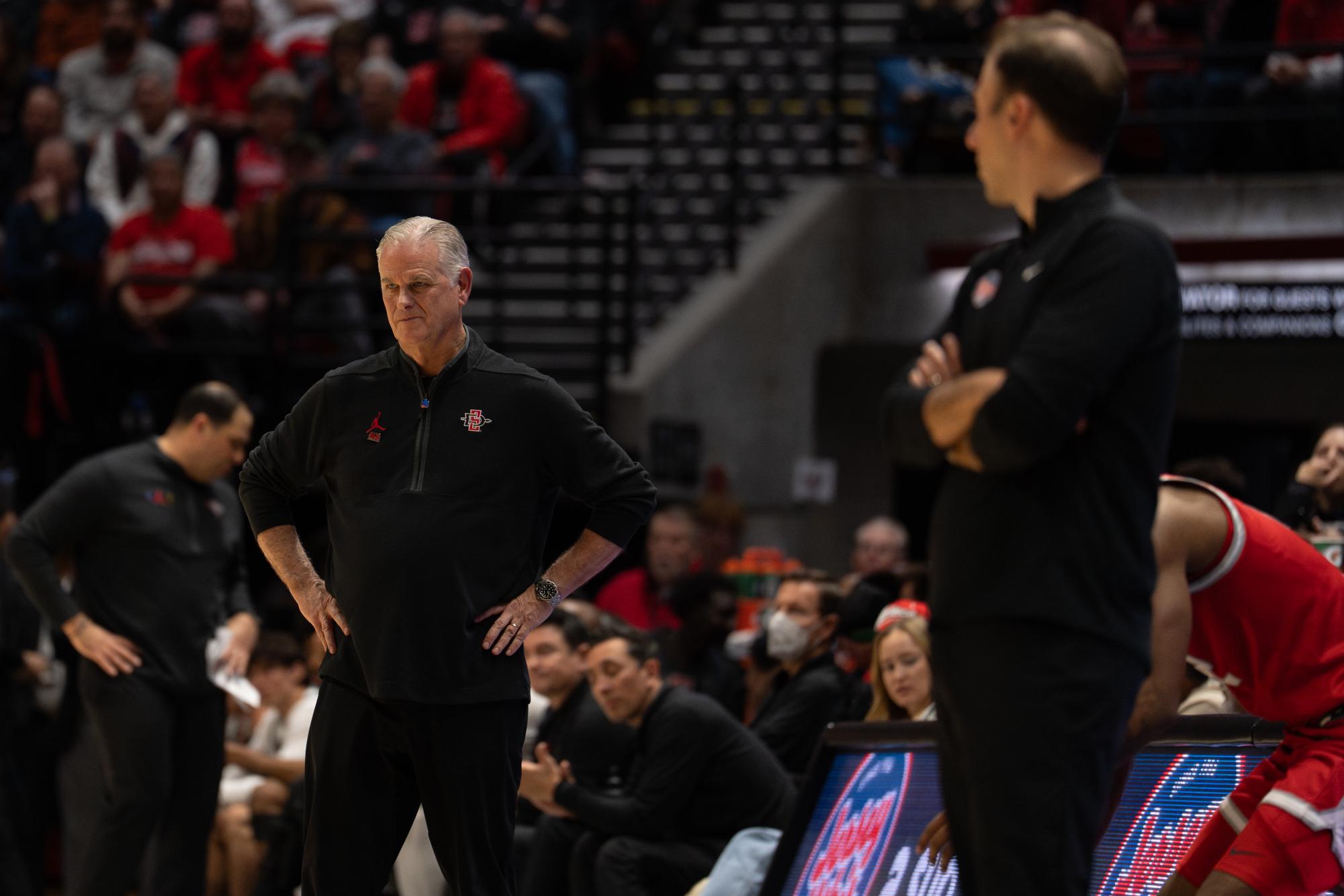 New Mexico head coach Richard Pitino (right) looks to head coach Brian Dutcher during their late-season game at Viejas Arena on Tuesday, Feb. 25, 2025 