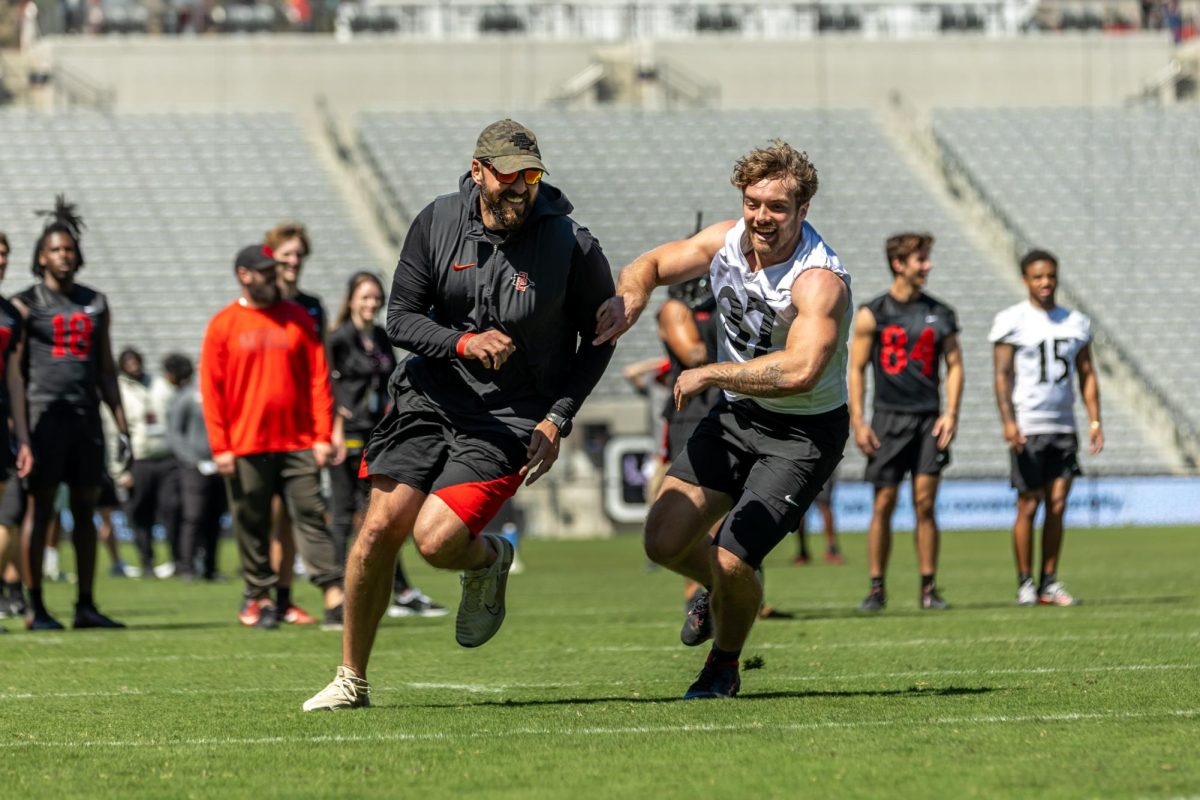 Head coach Sean Lewis runs across the field, as he briefly joins the scrimmage, at Snapdragon Stadium on April 19th, 2025.